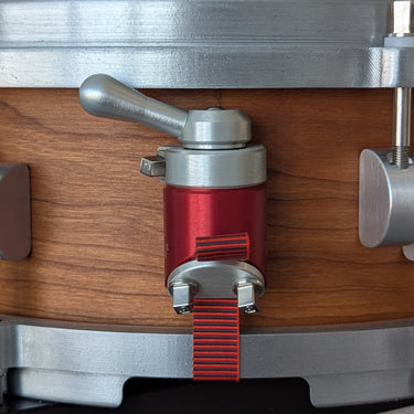 Side view of a cherry snare showing the NATO-1 XL throw off in aluminum finish